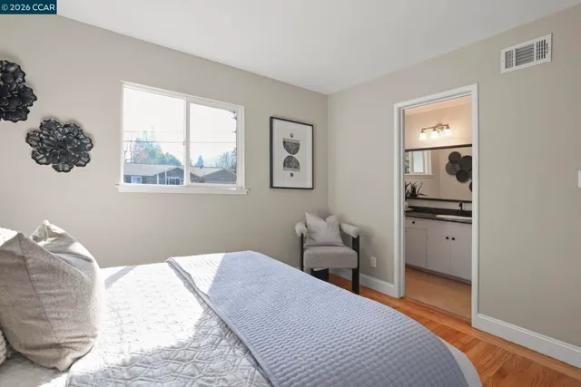 a bedroom with a bed and a painting on the wall