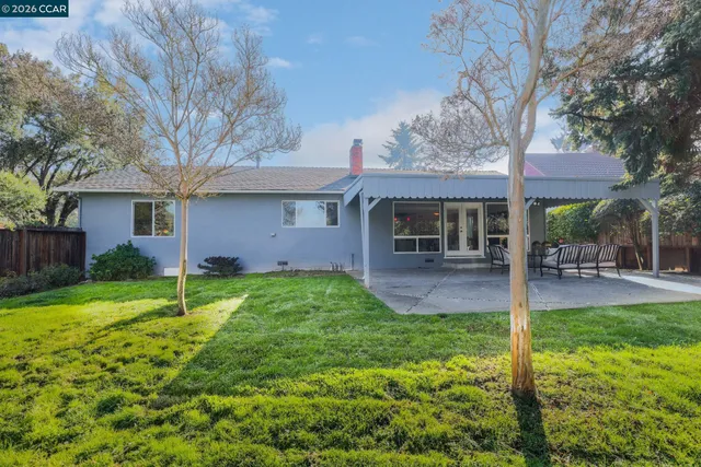 a view of a house with backyard and a tree