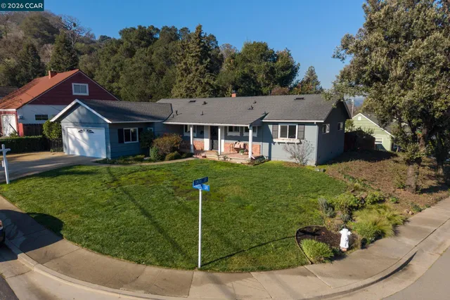 a front view of a house with a yard and trees