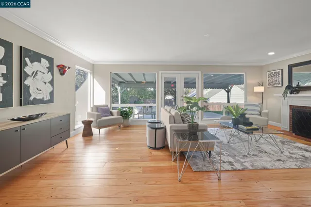 a living room with furniture large window and wooden floor