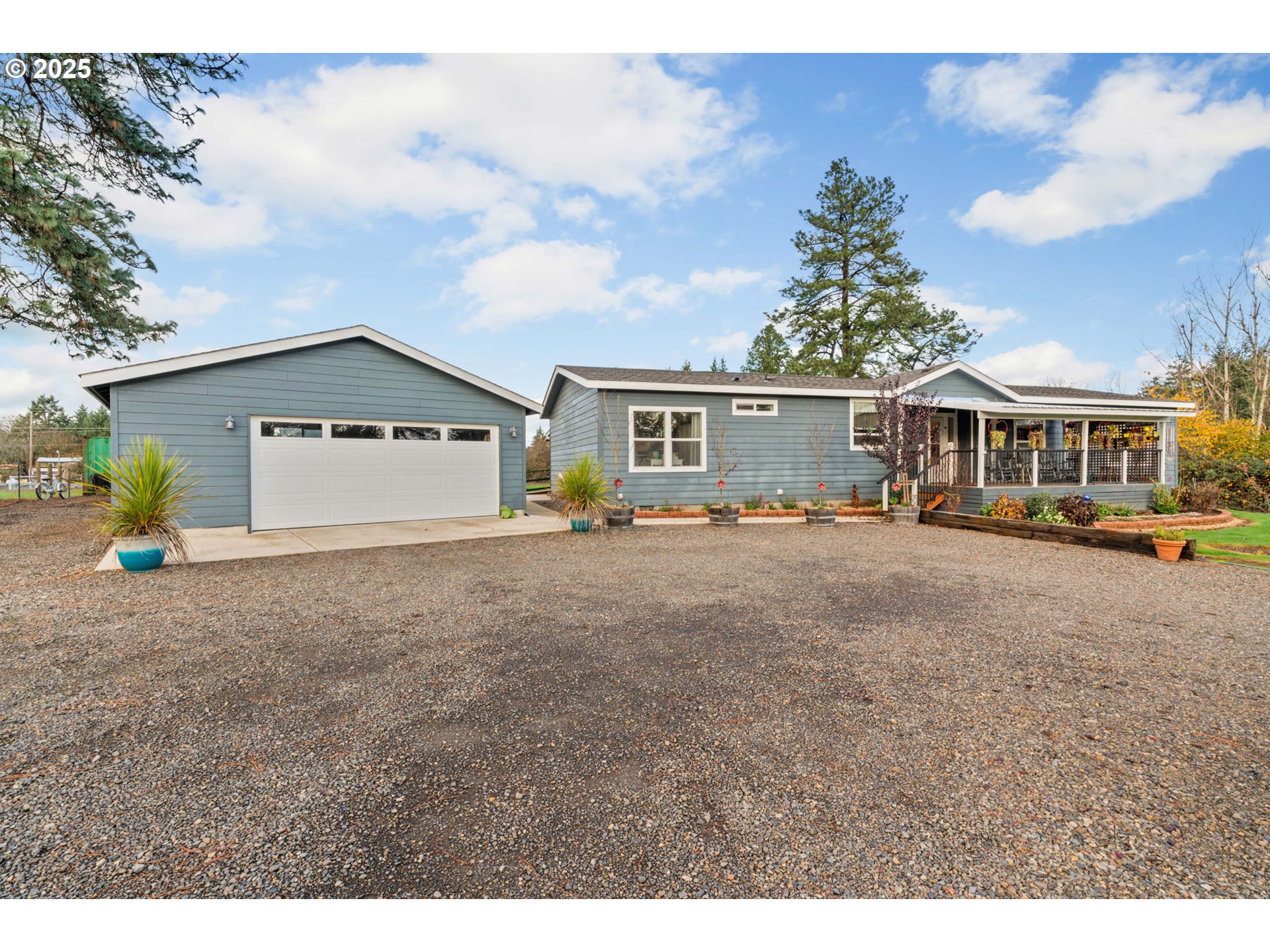 a view of a white house with a big yard and large trees
