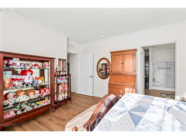 a bedroom with a bed and painting on the wall