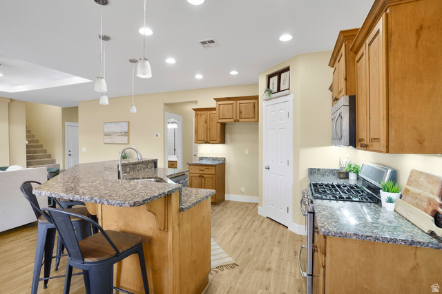 1570 South Rio Virgin Drive Washington, UT 84780 - Photo 20 of 71 Kitchen with stainless steel appliances, dark stone counters, pendant lighting, wood finish cabinets, and a kitchen breakfast bar
