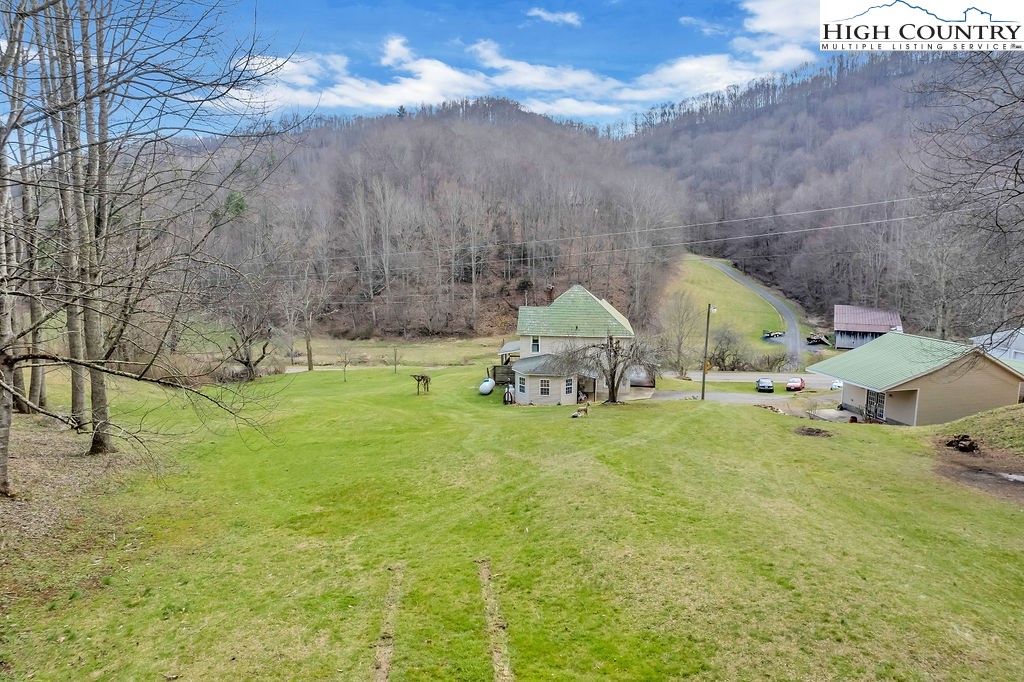 2136 Little Laurel Road Creston, NC 28615 - Photo 15 of 44 a backyard of a house with table and chairs