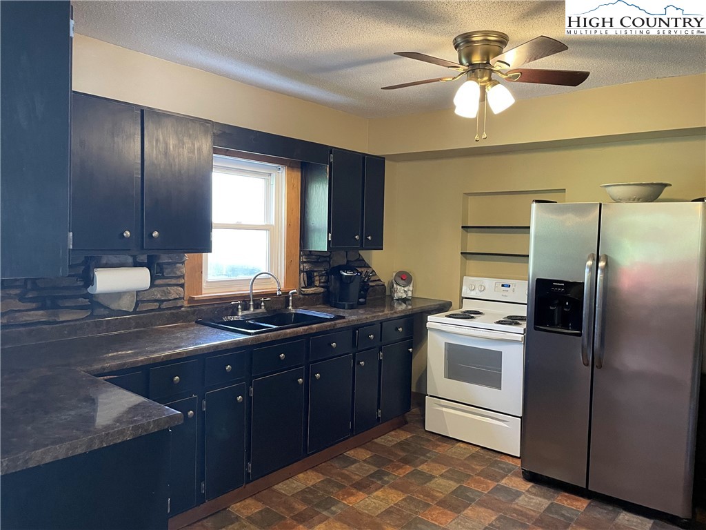 2136 Little Laurel Road Creston, NC 28615 - Photo 28 of 44 a kitchen with a sink stainless steel appliances and cabinets