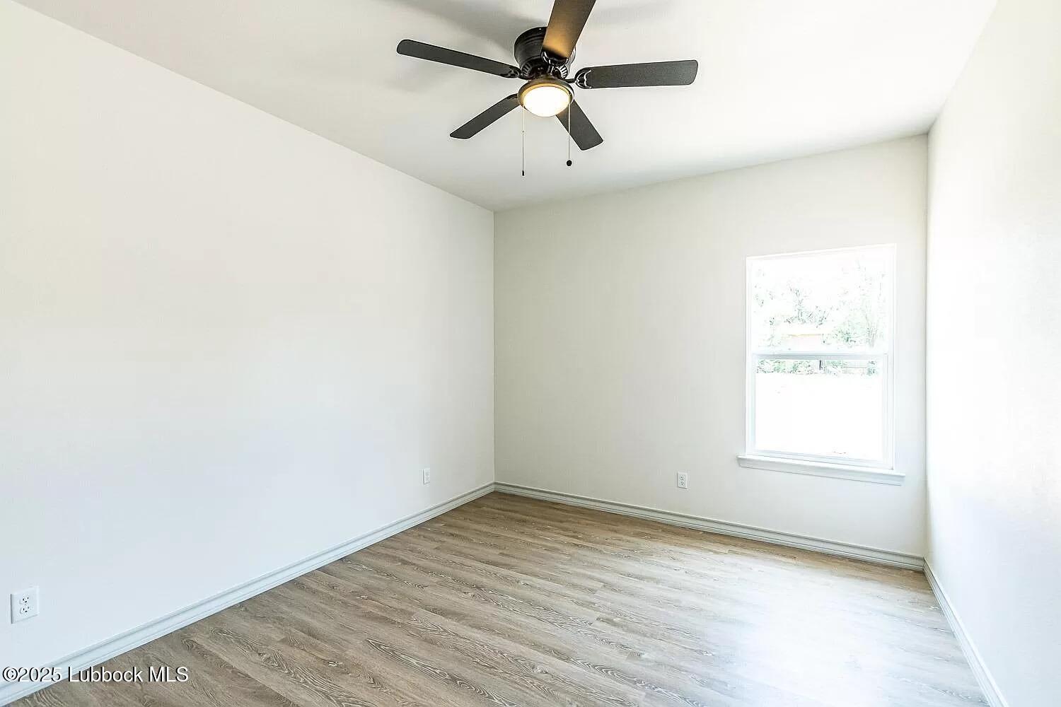 2113 20th Street, Unit A & B Lubbock, TX 79411 - Photo 13 of 31 an empty room with a window and a ceiling fan