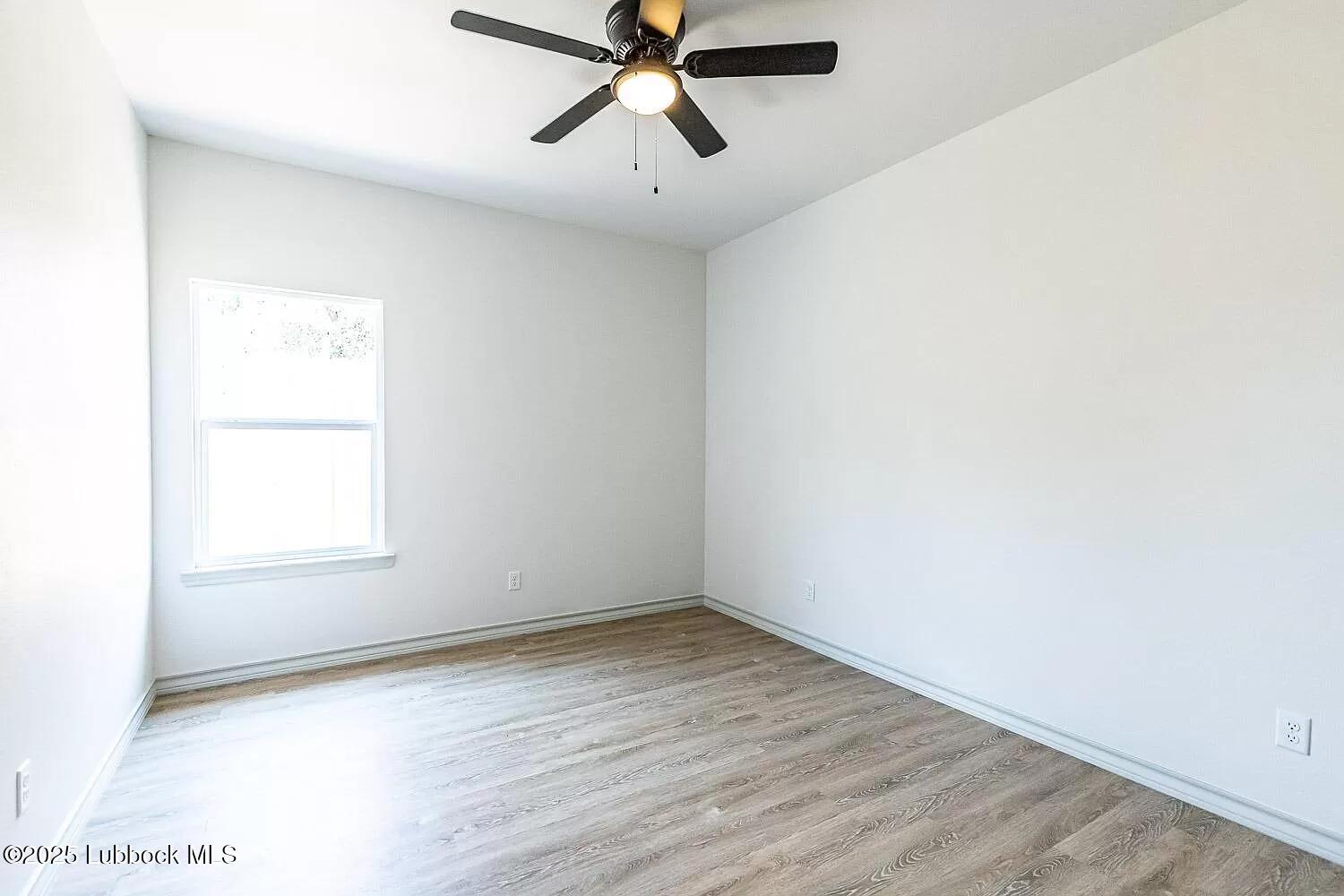 2113 20th Street, Unit A & B Lubbock, TX 79411 - Photo 14 of 31 an empty room with a window and a ceiling fan