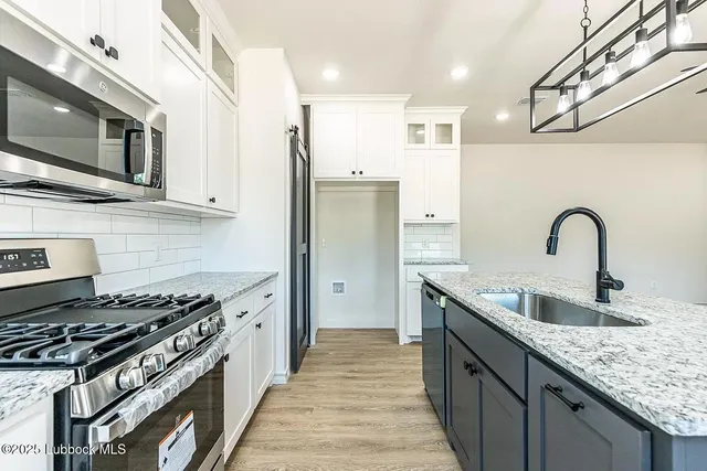 a kitchen with stainless steel appliances granite countertop a stove and a sink
