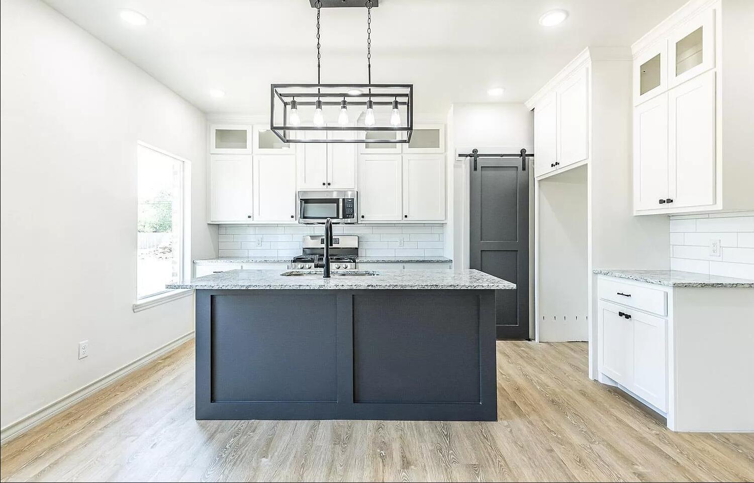 2113 20th Street, Unit A & B Lubbock, TX 79411 - Photo 29 of 31 a kitchen with stainless steel appliances granite countertop a sink cabinets and refrigerator