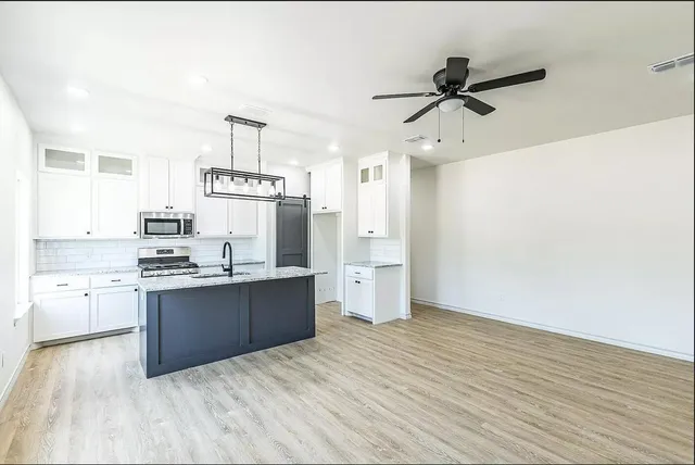a kitchen with a sink cabinets stainless steel appliances and a window