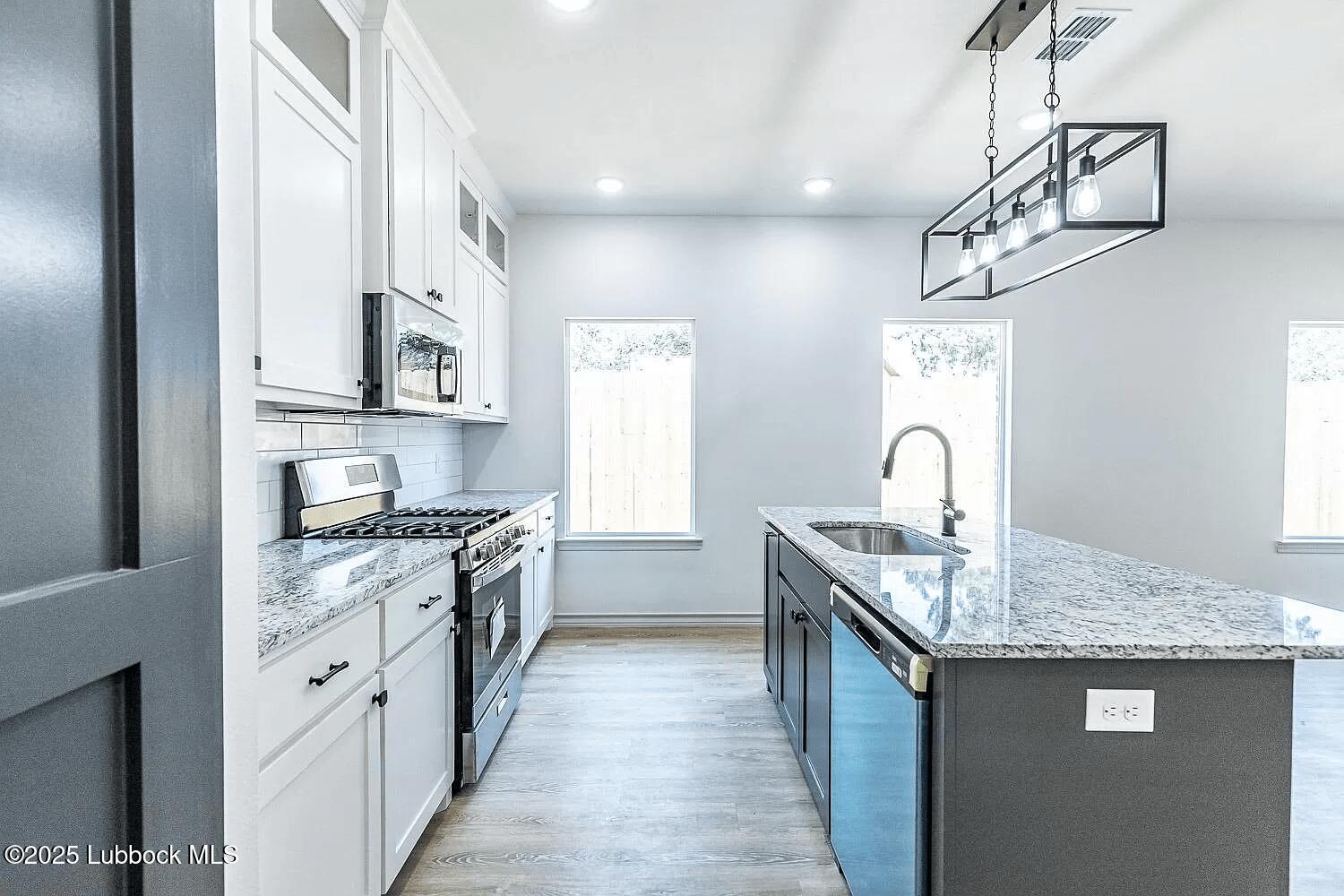 2113 20th Street, Unit A & B Lubbock, TX 79411 - Photo 3 of 31 a kitchen with stainless steel appliances granite countertop a sink and stove