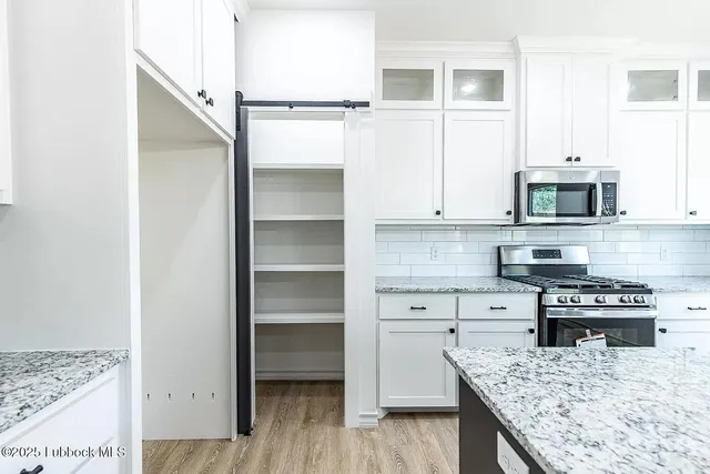 a kitchen with kitchen island white cabinets and appliances