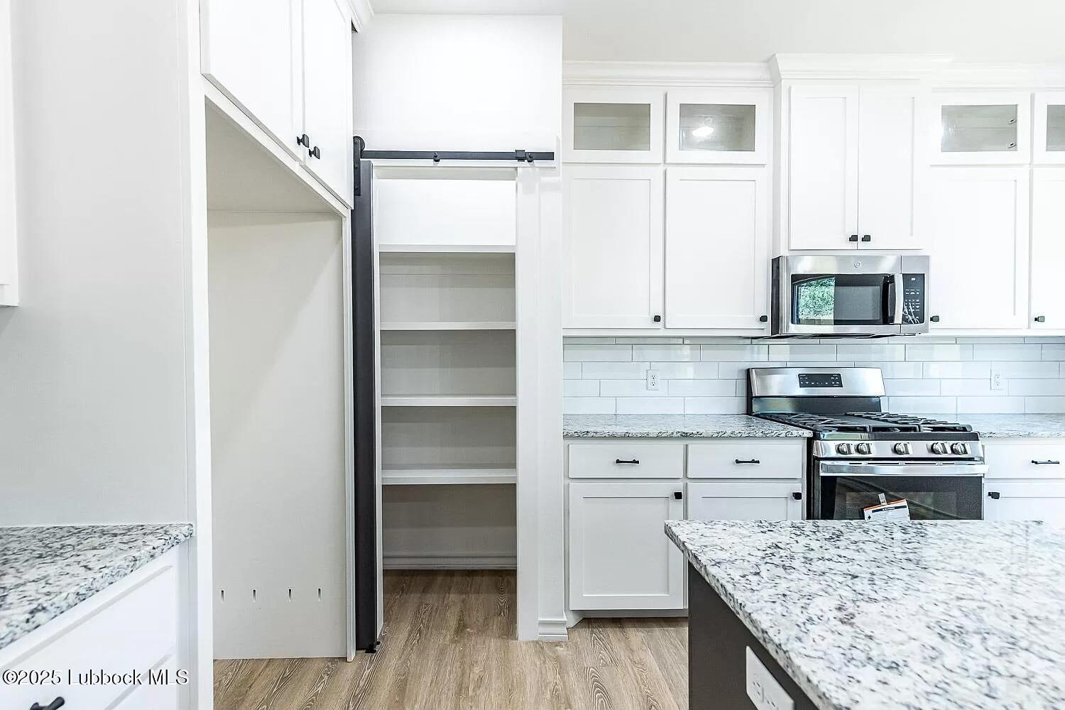 2113 20th Street, Unit A & B Lubbock, TX 79411 - Photo 5 of 31 a kitchen with kitchen island white cabinets and appliances