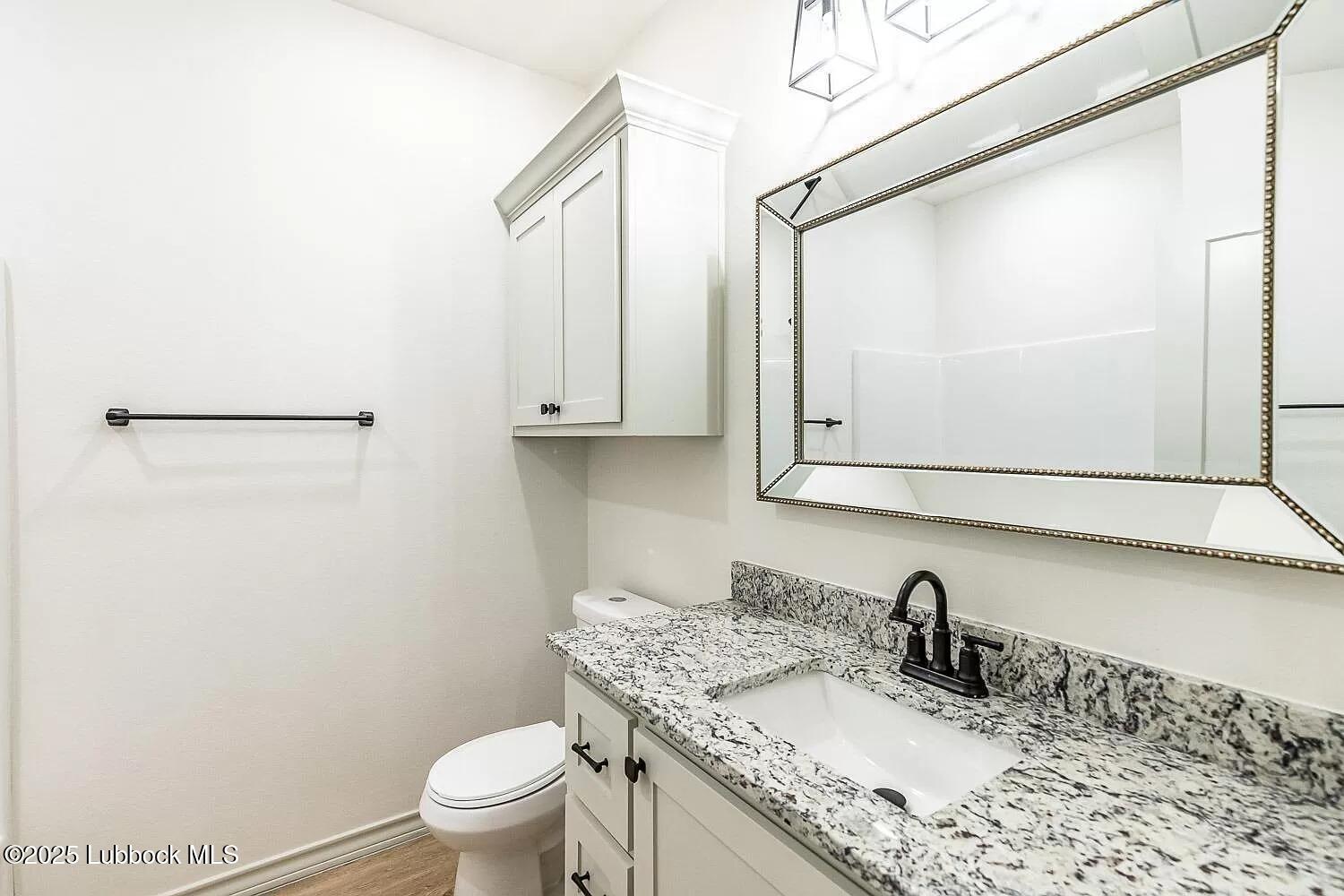 2113 20th Street, Unit A & B Lubbock, TX 79411 - Photo 6 of 31 a bathroom with a granite countertop sink toilet and mirror