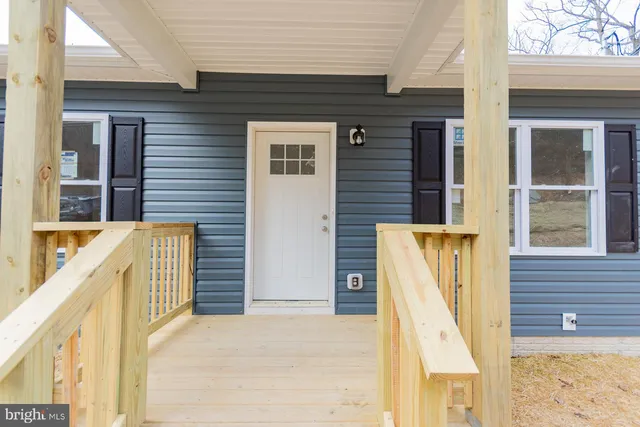 a view of balcony with two chairs and wooden fence