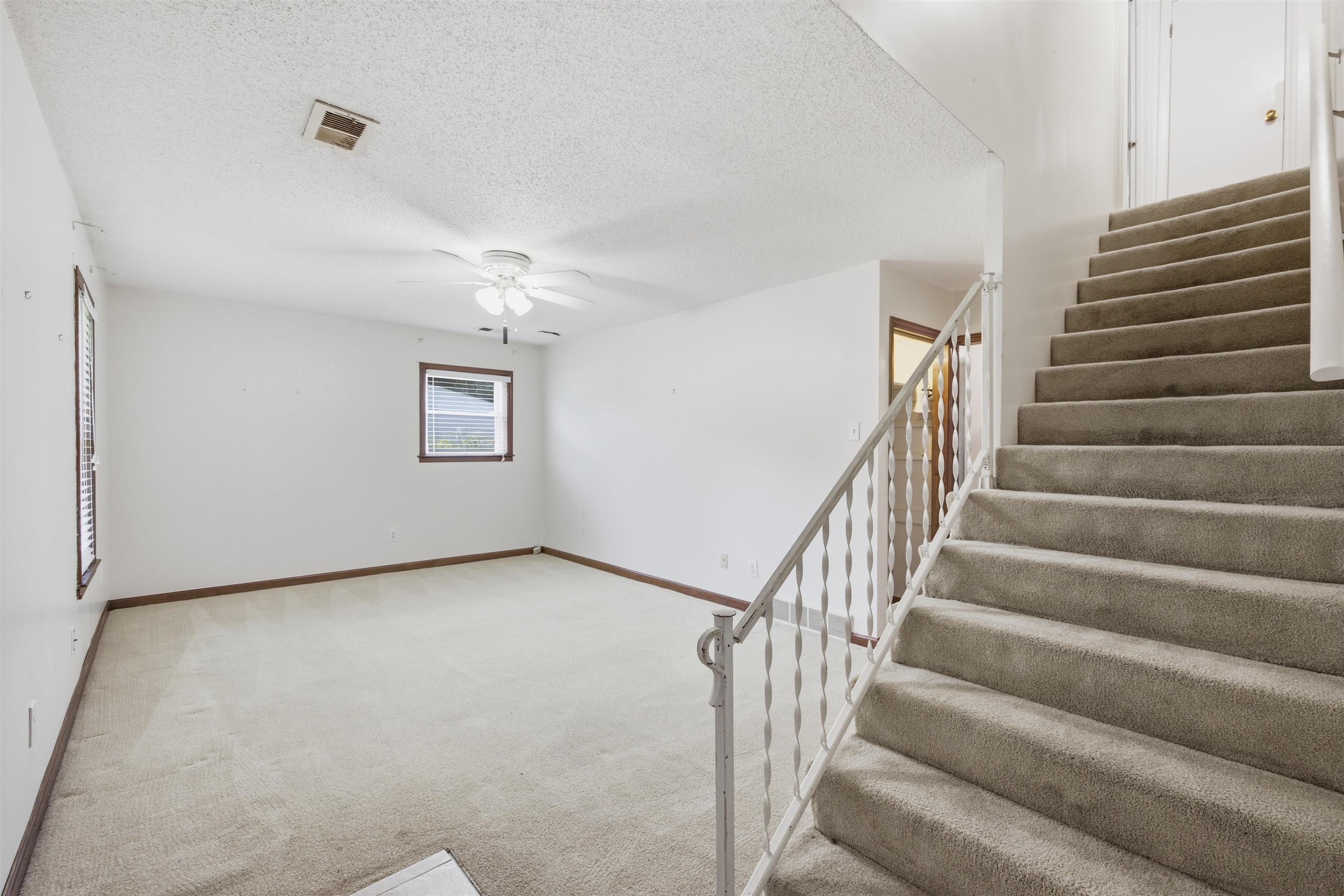 3007 Ruskin Road Bartlett, TN 38134 - Photo 14 of 37 Carpeted staircase with white metal balusters leading to an upper level
