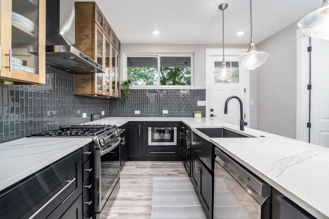 7905-7907 Tiffany Drive Austin, TX 78749 - Photo 12 of 37 a kitchen with stainless steel appliances granite countertop a sink stove and cabinets