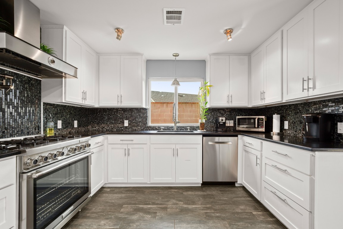 7905-7907 Tiffany Drive Austin, TX 78749 - Photo 10 of 37 a kitchen with stainless steel appliances granite countertop a stove a sink and a refrigerator