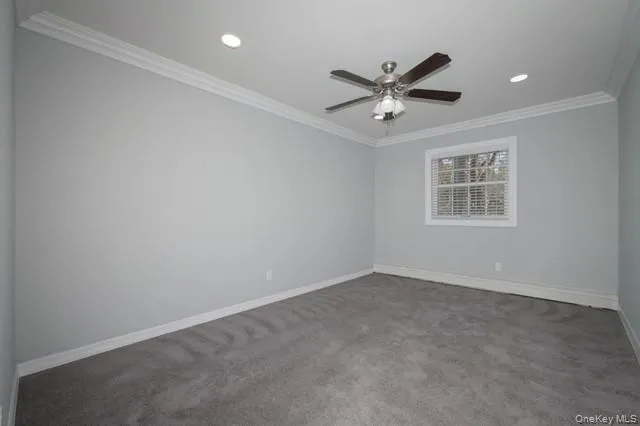 an empty room with window and ceiling fan