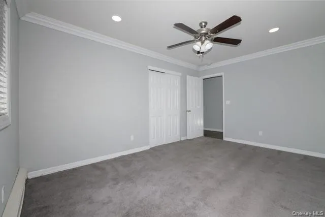 an empty room with ceiling fan and window