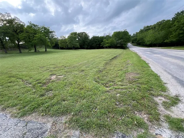 a view of a field with trees in the background