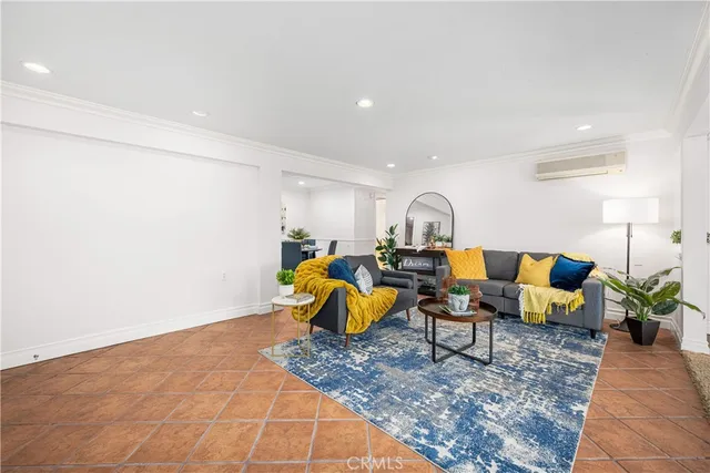 a living room with furniture and a dining table with kitchen view