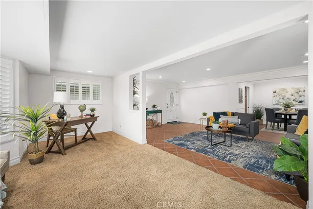 a living room with furniture floor to ceiling window and potted plants