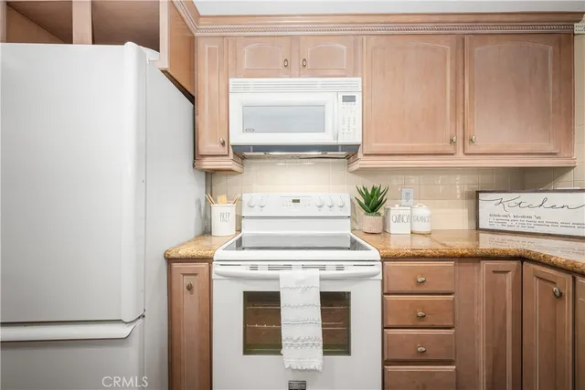 a kitchen with a stove a refrigerator and a microwave