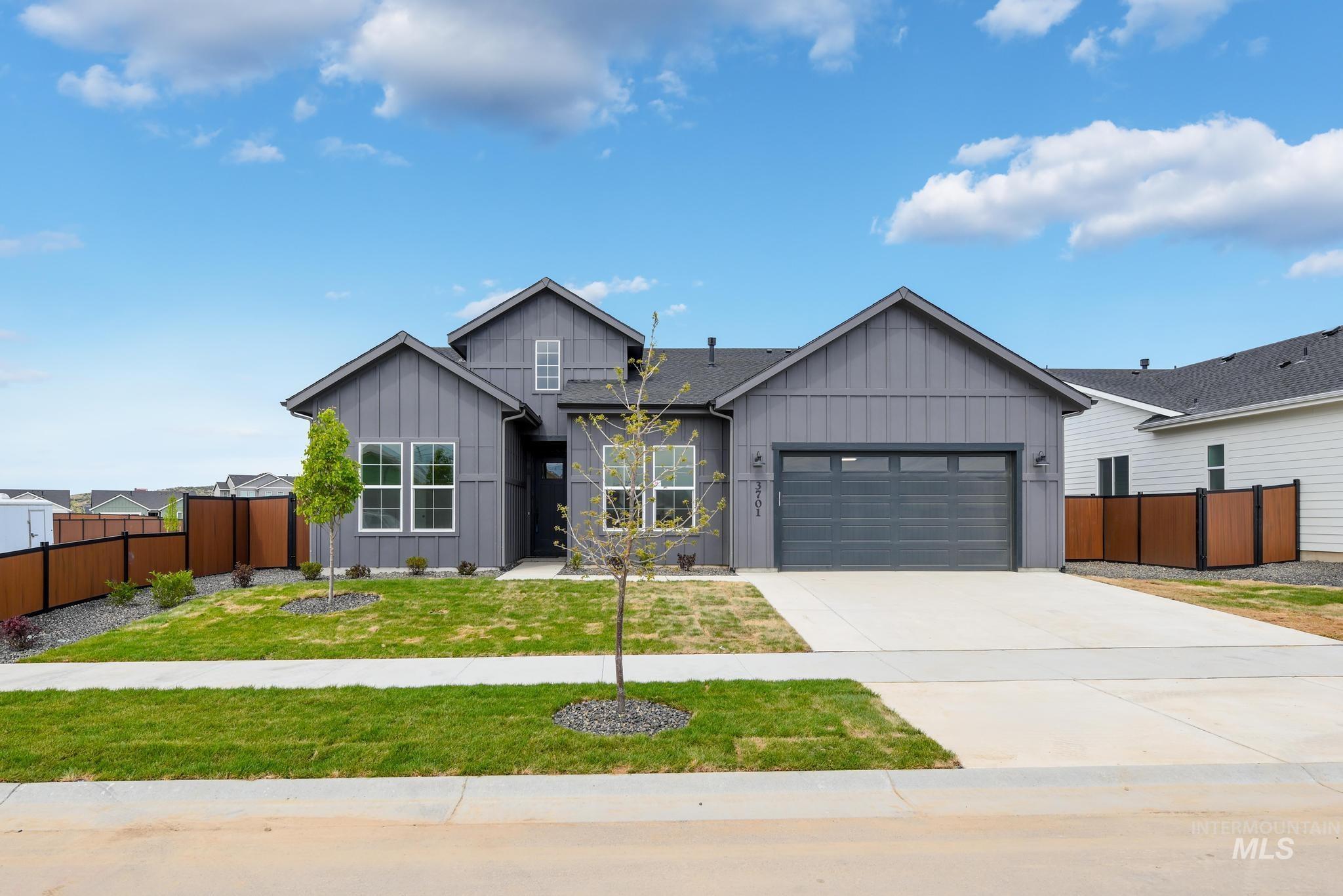 View of front of property featuring board and batten siding, concrete driveway, and an attached garage
