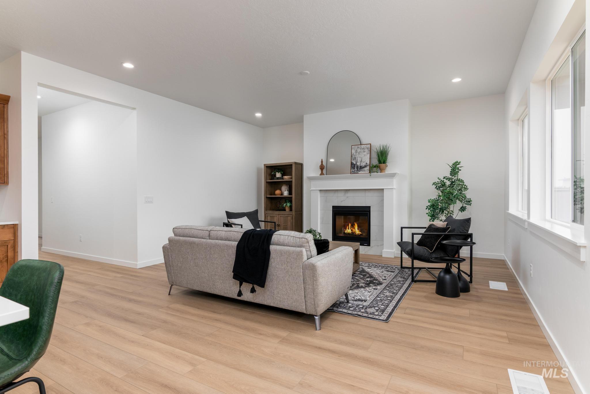 9767 West Nicasio Drive Star, ID 83669 - Photo 2 of 12 Living area featuring a fireplace, light wood-style floors, and recessed lighting
