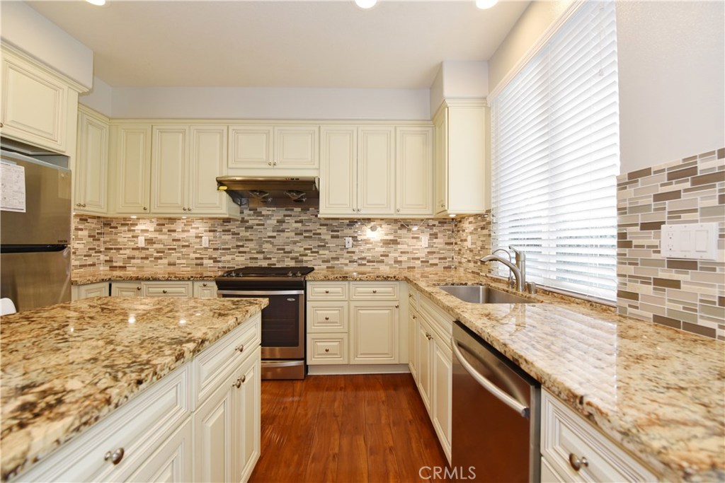 24 Silveroak Irvine, CA 92620 - Photo 16 of 64 a kitchen with stainless steel appliances granite countertop a sink stove and cabinets