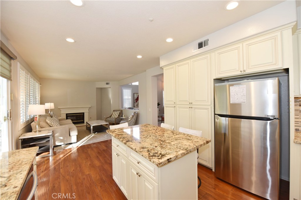 24 Silveroak Irvine, CA 92620 - Photo 22 of 64 a kitchen with stainless steel appliances granite countertop a refrigerator a stove a sink dishwasher and a dining table with wooden floor