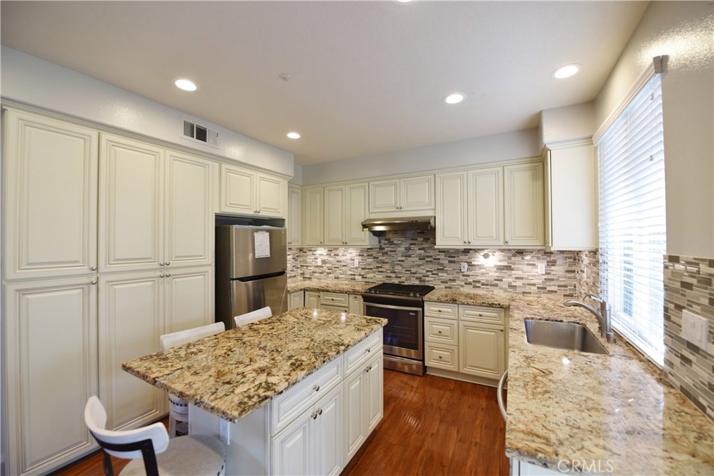 24 Silveroak Irvine, CA 92620 - Photo 24 of 64 a kitchen with stainless steel appliances granite countertop a sink stove and refrigerator