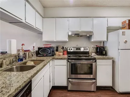 a kitchen with cabinets appliances and a sink