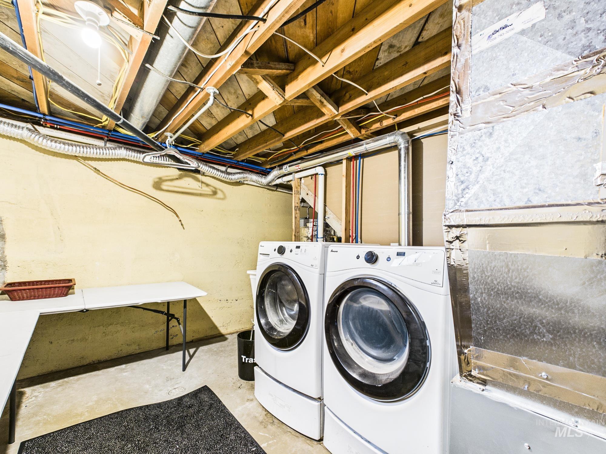 3422 6th Street Lewiston, ID 83501 - Photo 27 of 43 Dedicated laundry area featuring a washer and dryer set, exposed ceiling joists, utility piping, and a concrete floor