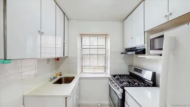 a kitchen with a sink a stove and cabinets