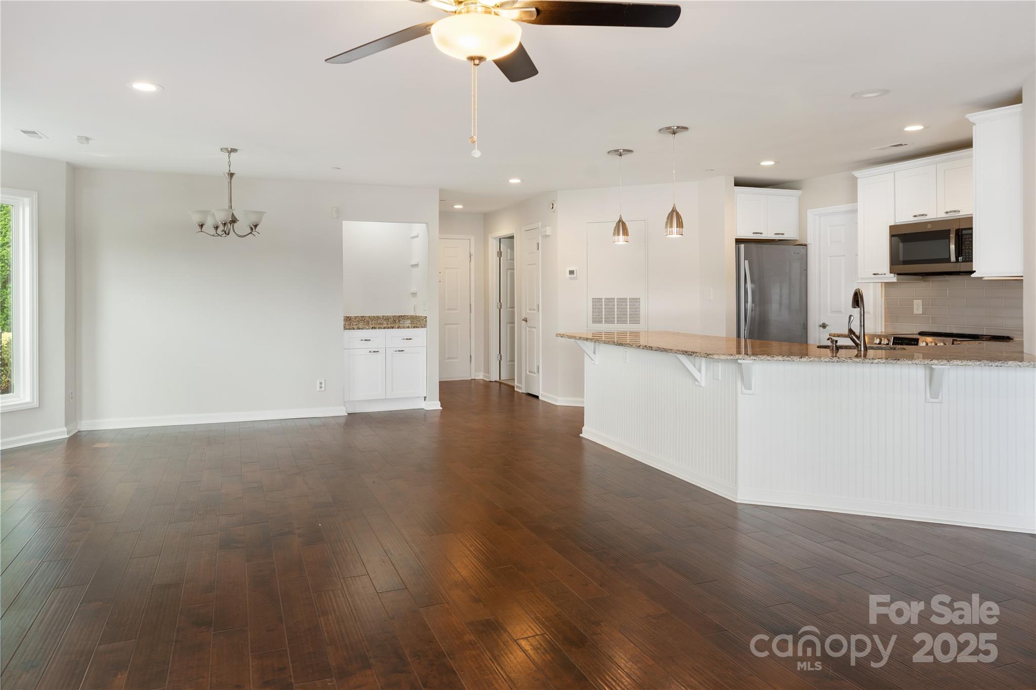 18647 Vineyard Point Lane Cornelius, NC 28031 - Photo 15 of 36 a large kitchen with stainless steel appliances kitchen island wooden cabinets and granite counter tops