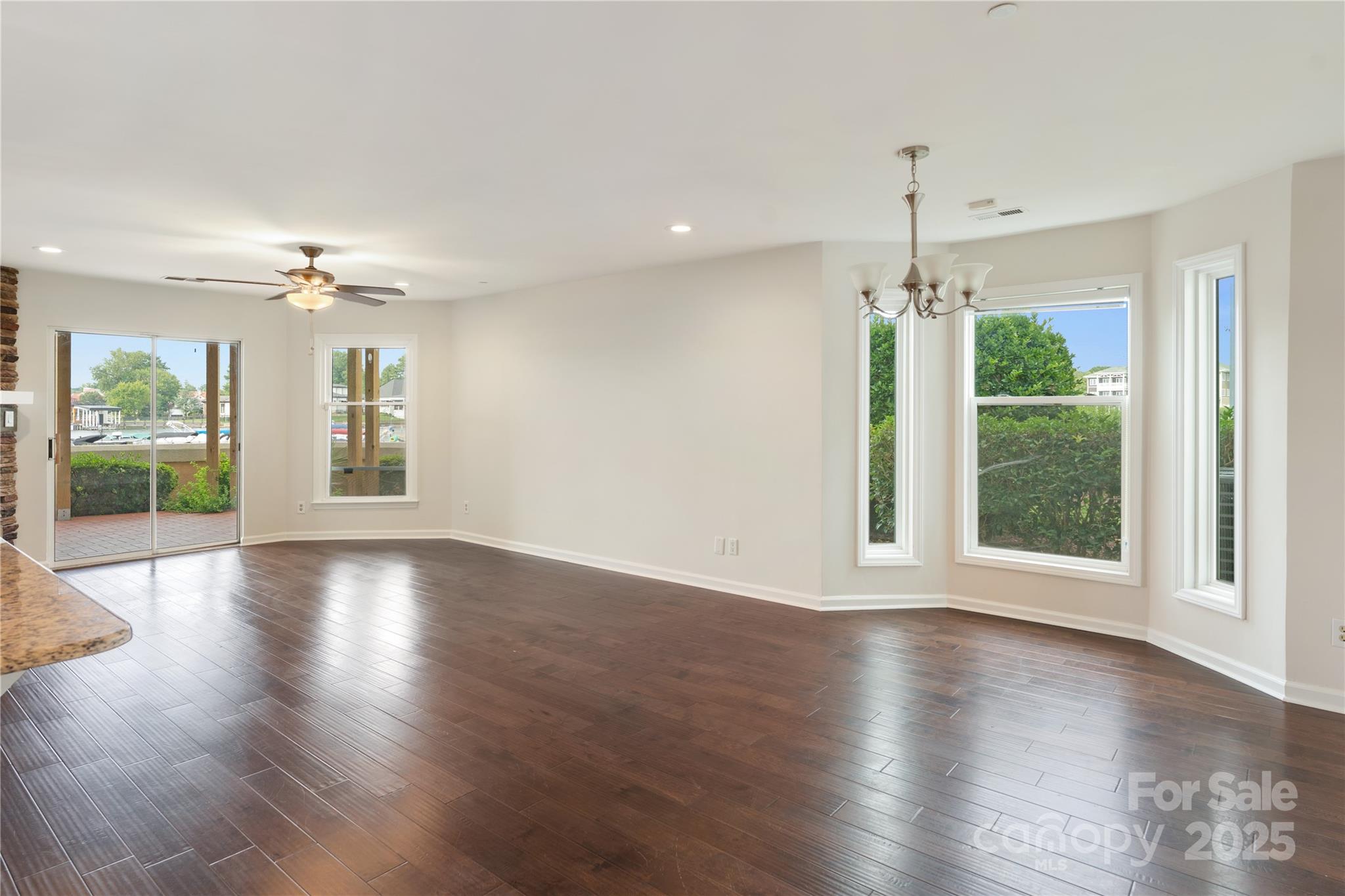 18647 Vineyard Point Lane Cornelius, NC 28031 - Photo 16 of 36 an empty room with wooden floor and large windows