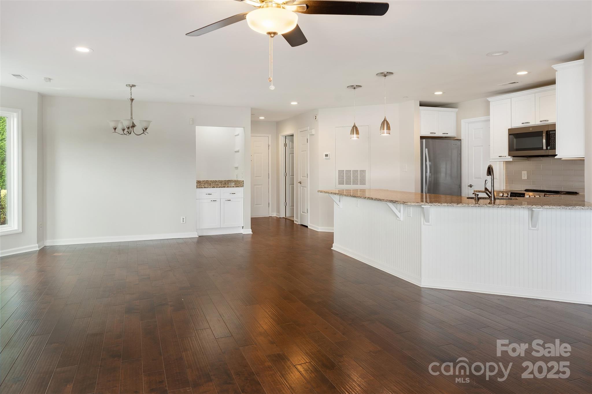 18647 Vineyard Point Lane Cornelius, NC 28031 - Photo 17 of 36 a large kitchen with stainless steel appliances kitchen island wooden cabinets and granite counter tops
