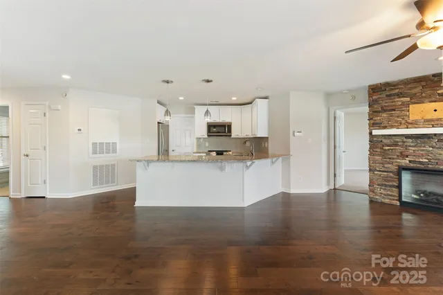 a view of kitchen with granite countertop cabinets and refrigerator