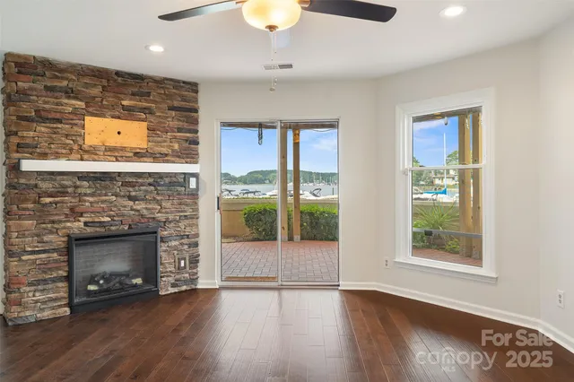 an empty room with windows and fireplace