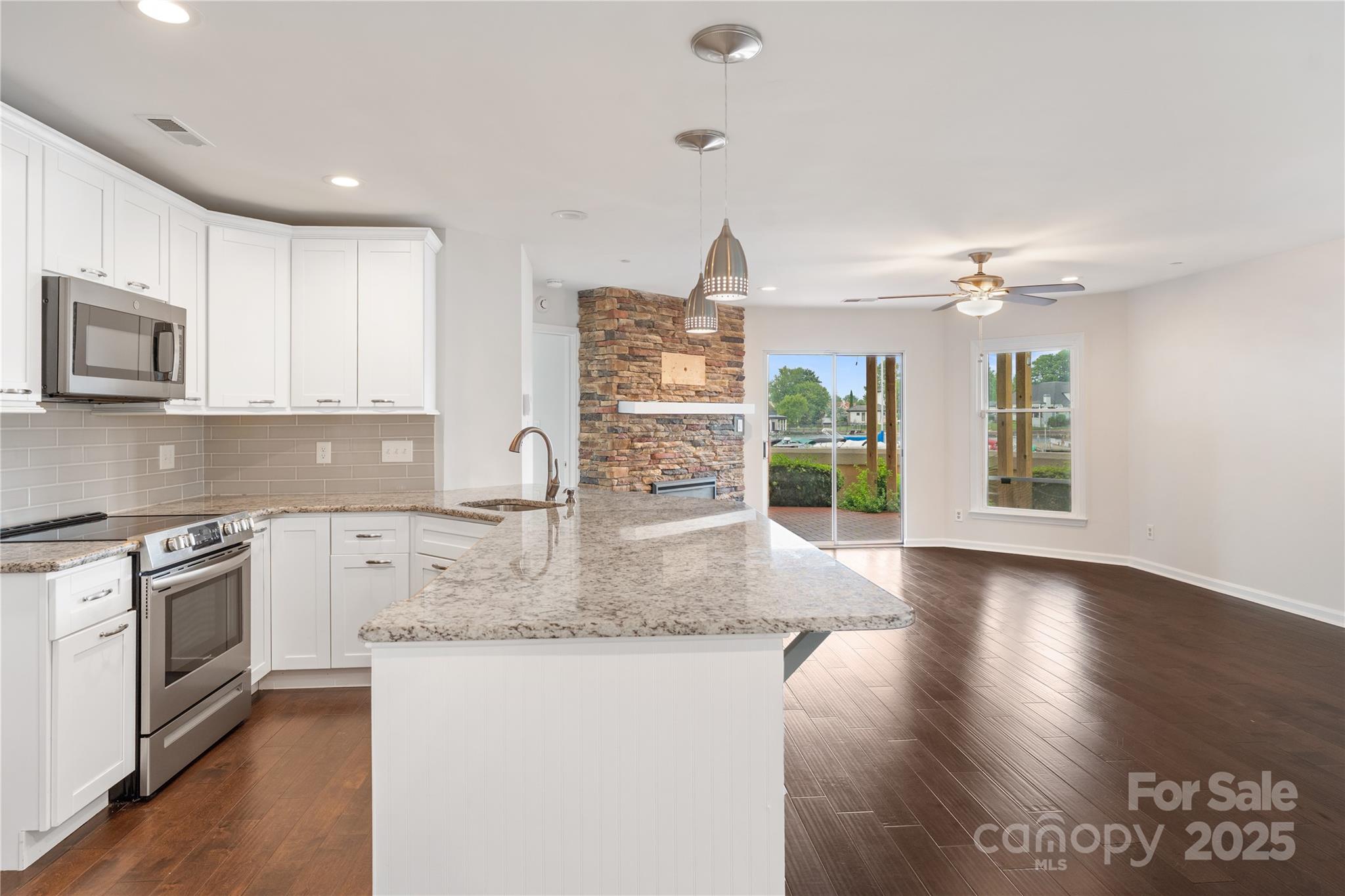 18647 Vineyard Point Lane Cornelius, NC 28031 - Photo 24 of 36 a kitchen with stainless steel appliances granite countertop a stove a sink and a microwave