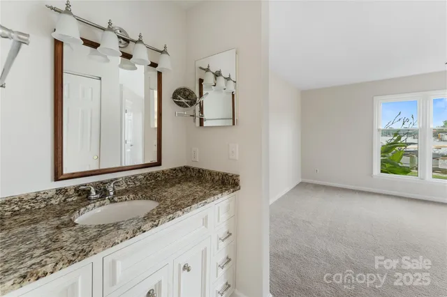a bathroom with a granite countertop sink and a mirror