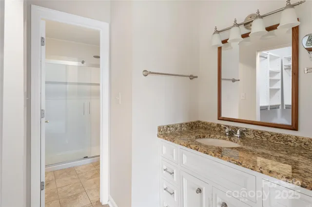a bathroom with a granite countertop sink and shower