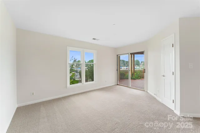 a view of a big room with windows and chandelier fan