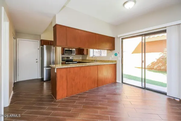 a kitchen with stainless steel appliances granite countertop a refrigerator a sink and a stove