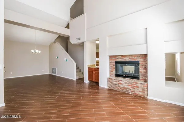 a view of an empty room with wooden floor fire place