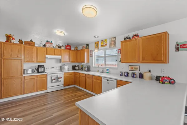 a kitchen with stainless steel appliances granite countertop a sink cabinets and wooden floor