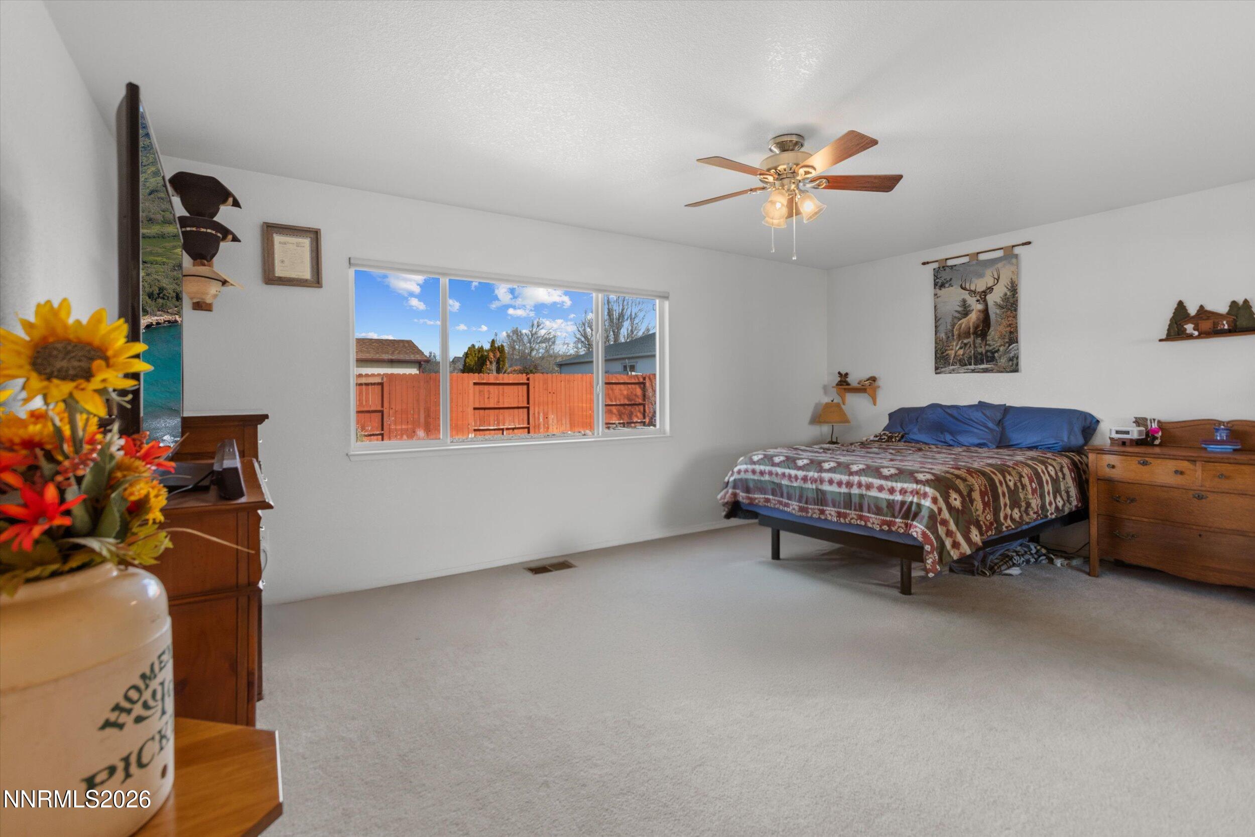 17533 Javalina Court Reno, NV 89508 - Photo 10 of 26 a spacious bedroom with a bed and a chandelier