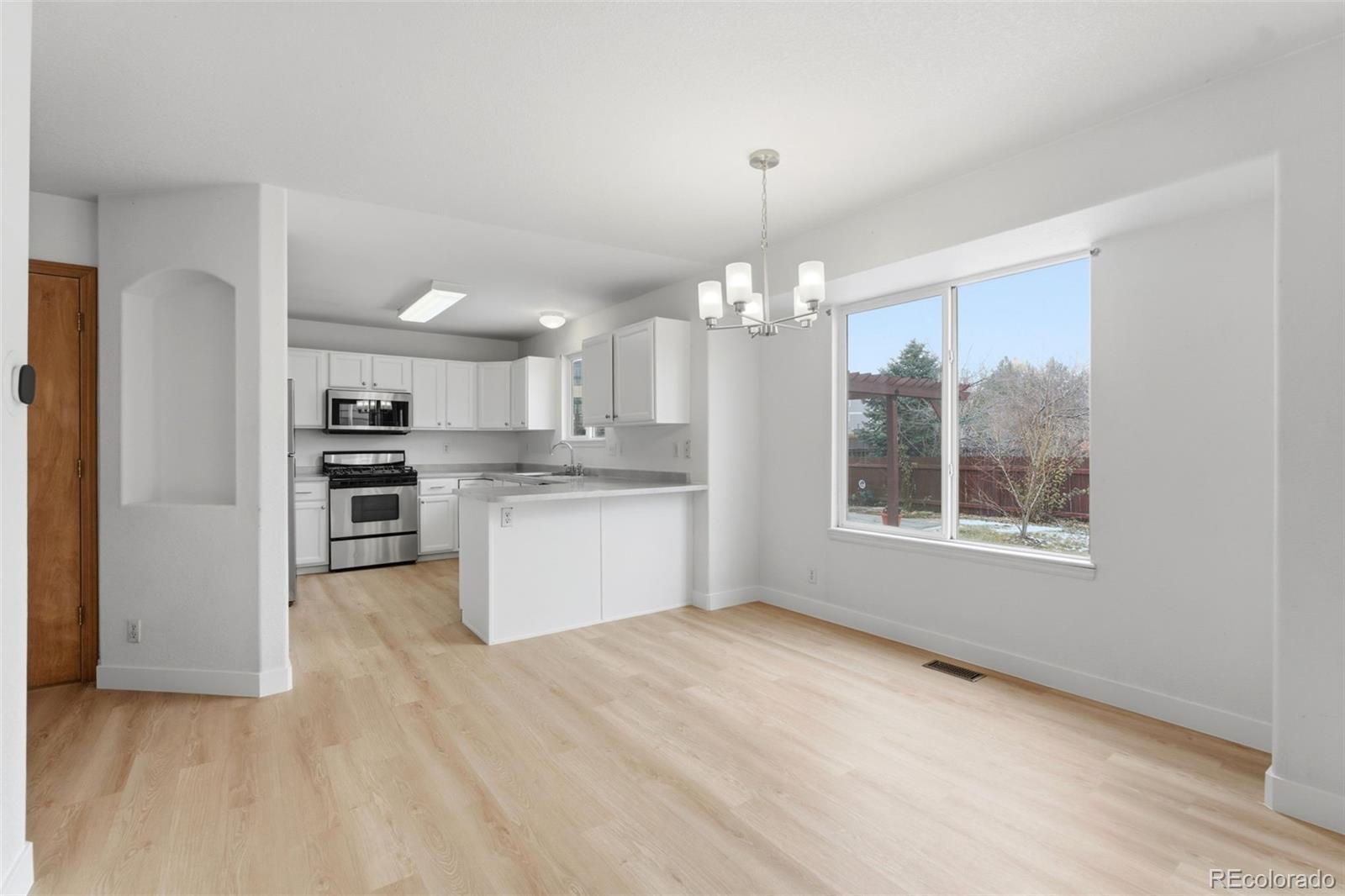 10505 Madison Way Northglenn, CO 80233 - Photo 13 of 49 a view of a kitchen with a sink wooden cabinets and a window